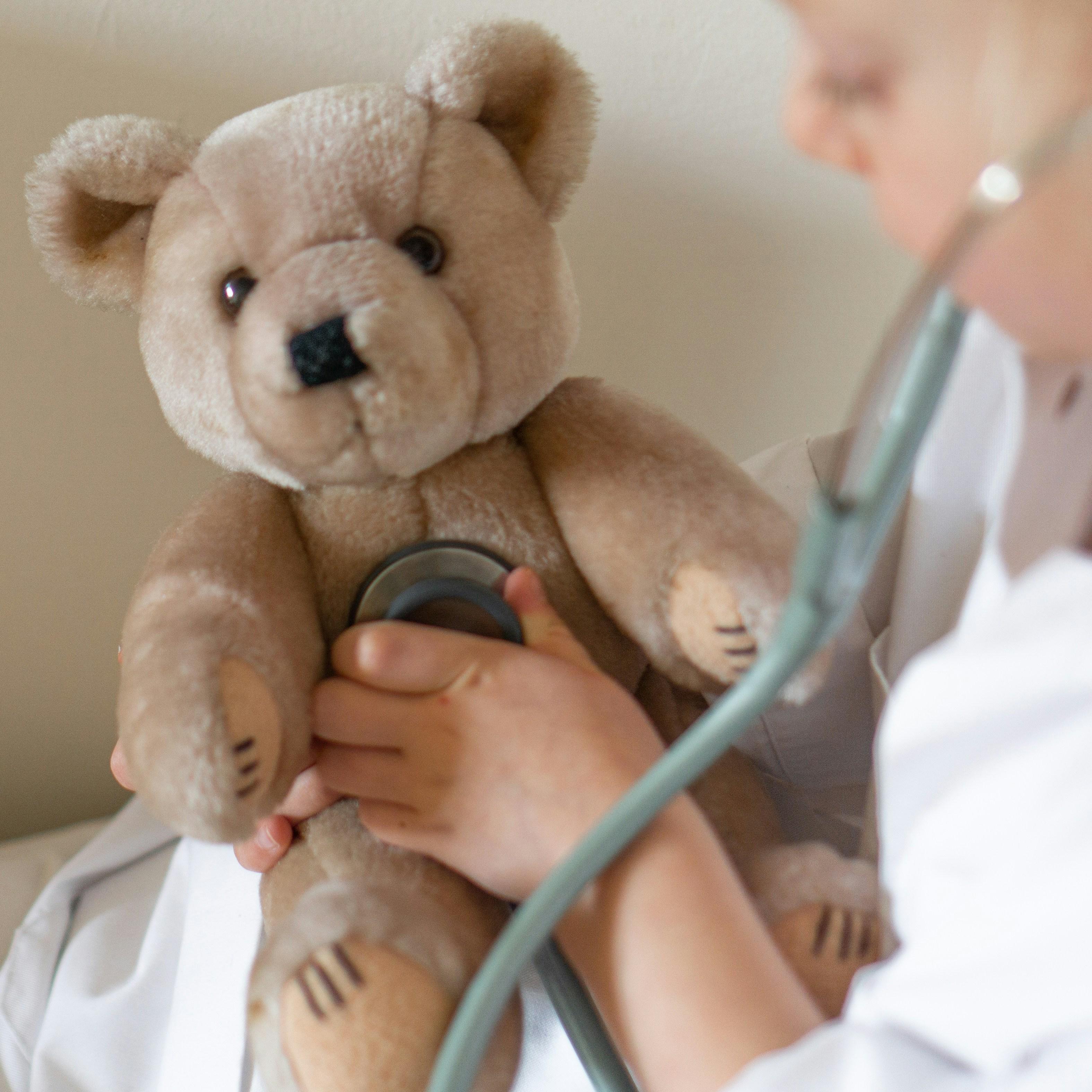 Holding a teddy bear.